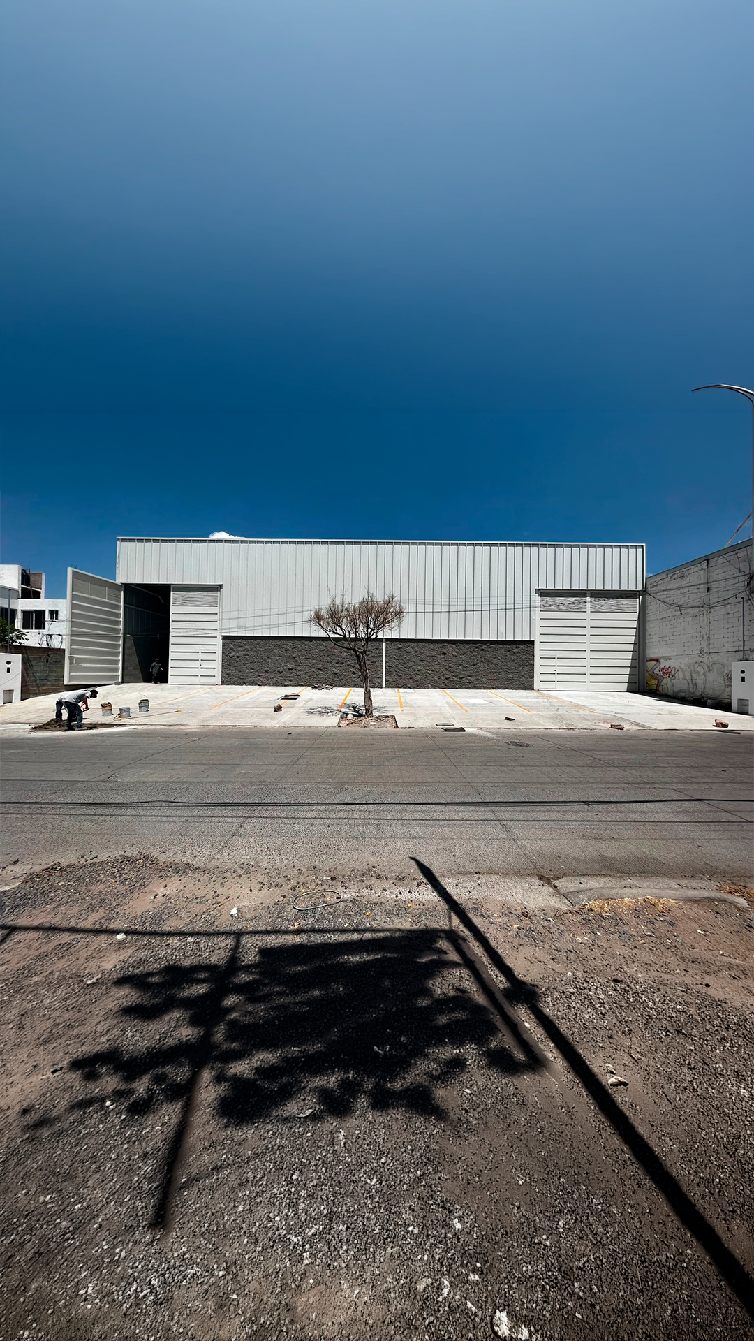 Fachada exterior de bodegas Valtierra con acceso vehicular amplio, construcción industrial Fer Et Ciment en Guanajuato